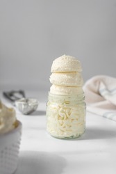 Three scoops of american buttercream in a glass jar, scoops of buttercream with air pockets, textured buttercream in a glass jar, scoops of ice cream in glass cup