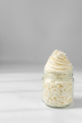 Piped swirl of american buttercream in a glass, buttercream swirl on glass, textured buttercream in glass jar