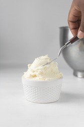 American buttercream in a white ramekin, buttercream with air pockets, textured buttercream in hobnail bowl