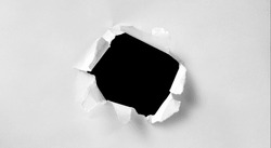 A hole in white paper with torn edges and a black isolated background inside, Ripped black and white paper, copy space