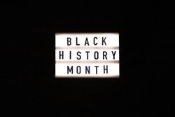 Lightbox with text BLACK HISTORY MONTH on dark black background. Message historical event. Light