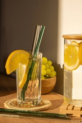 Glass of water with fresh lemon juice with Reusable glass Straws Detox cold tonic water with sunny lemon slices Low-waste lifestyle Eco-Friendly Drinking Straw 