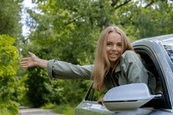 Blonde woman sticking head out of windshield car. Young tourist explore local travel making candid real moments. True emotions expressions of getting away and refresh on open clean air