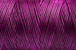 A coil of purple thread. Spool of colored threads on a white background. Waxed sewing thread for leather crafts.