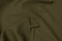 Folded olive green colored mixed fabric texture background. This is made of linen and polyester.
