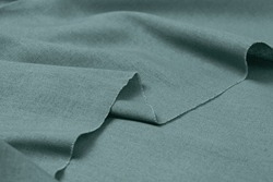 Folded green-colored mixed fabric texture background. This is made of linen and polyester.
