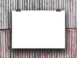 One hanged horizontal paper sheet with clips on vertical clay tiles wall background