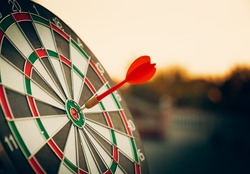bullseye target or dart board has red dart arrow throw hitting the center of a shooting for business targeting and winning goals business concepts.