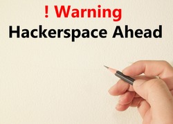 Red and white warning road sign with a Hackerspace ahead concept  on wall 