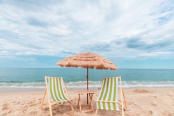 Straw beach rattan parasol with green beach chairs at the beach with blue sky backgrounds. Relax at the beach