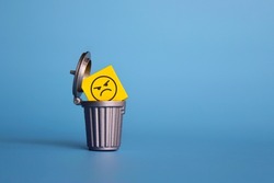 Remove negative thoughts, anger management concept. Wooden cube with angry face icon inside dustbin, trash can.