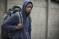 Homeless Teenage Boy On Streets With Rucksack