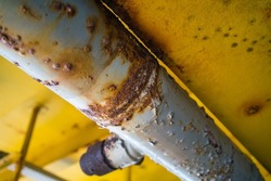 Steel pipe with blister paint, rust paint peeling off against the surface of the pipe.