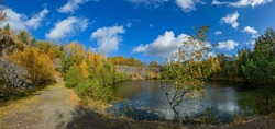 flooded quarry surrounded by trees in autumn