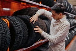 male customer choosing new tires in the supermarket .