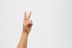 The left hand with the thumb, ring finger and little finger bent to form the number two symbol on a white background