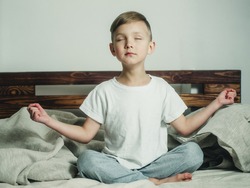 boy in lotus position on the bed