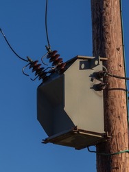 Powerline transformer on a wooden telegraph pole in the UK. Energy supply component.