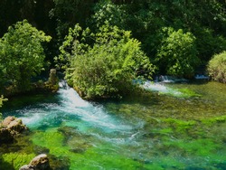 Photo of a magnificent and soothing provencal landscape with the pure and translucent water of the Sorgue river. This photo was taken at Fontaine de Vaucluse in Provence.