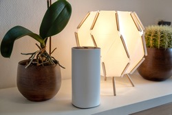 Stylish Wifi signal repeater in interior design on a shelf with flower pots