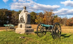 A Union monument and civil war cannons in the Wheatfield on the Gettysburg National Military Park on a sunny fall day