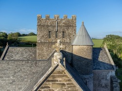 Top of old church building with Christian cross at Avon Gifford church in Devon, UK