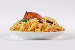 Isolated side view of chicken biryani with yogurt on white background, traditional spicy indian food. Pakistani fried rice. Ramadan dinner or iftar meal.