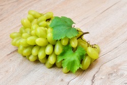 A large bunch of fresh green grapes, beautiful wood grain background