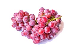 Red grapes, fruit heap, heart shape isolated on white background.