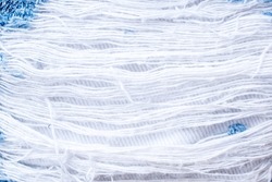 Textured white yarn ripped jeans close-up abstract background