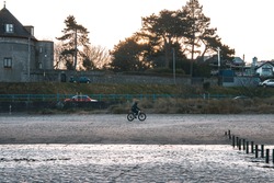 A Person Riding A Bike On The Malahide Beach