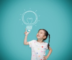 Asian child girl pointing at the blackboard with imagination the light bulb, Creative and dreams of childhood concept