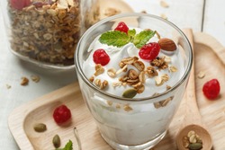 Greek yogurt in a glass with spoons on wooden background