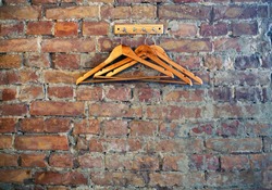 Bricks wall background with rack and wooden clothes hangers, cafe restaurant wardrobe corner, loft style 