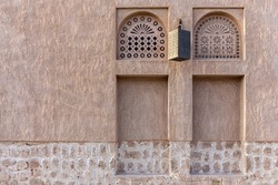 Arabic style window portals in stone wall with ornaments, traditional arabic architecture, Al Fahidi, Dubai, United Arab Emirates, copy space.