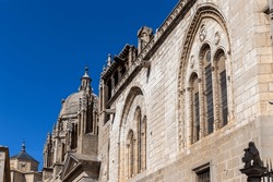 Toledo Cathedral (The Primatial Cathedral of Saint Mary of Toledo) richly decorated Gothic facade with carved windows arches, spires and dome of the Mozarabic chapel.