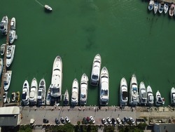 Aerial panoramic view of Balaklava landscape with boats and sea in marina bay. Crimea Sevastopol tourist attraction. Drone top view shot of port for luxury yachts, boats and sailboats.