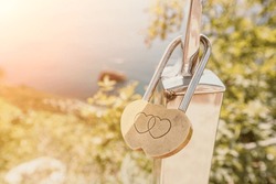 Wedding Heart Golden Lock on stainless iron fence. Valentine's day. Symbol of eternal love. A wedding tradition all over the world to hinder the lock. Monument on the wedding day.