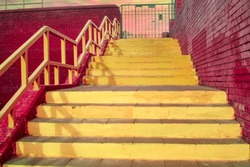 The yellow staircase and brick walls of the trend color vivid magenta. Ascent to the sunset sky. Geometry in architecture. Bright colors. Space for text. Copy space
