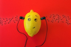 One lemon in the phone's headphones is enjoying music. Musical concept.