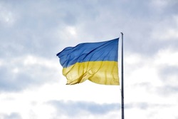 Large national flag of Ukraine flies in the blue sky. Big yellow blue Ukrainian state banner in the Kharkiv city. Independence, flag, Constitution Day, National Holiday, text space.