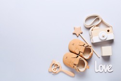 Set of baby shoes, toys and accessories on grey background. Newborn stuff. Flat lay, top view