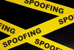 Spoofing cybercrime alert, caution and warning concept. Yellow barricade tape with word spoofing in dark black background.