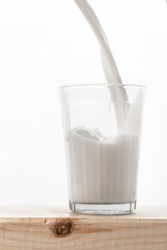 milk is poured into a faceted glass, which stands on a wooden table