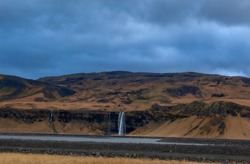 A high-altitude mountain plateau with a waterfall. Yellow and brown colors of the autumn season. Iceland.