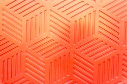Red plastic surface with repetitive geometric shapes. Seamless geometrical patterns with rhombuses, lines and corners. Stamped plastic surface with simple geometric lines. Space for inserting text