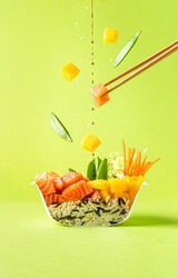 Poke sushi bowl with salmon. Food cut in half. Levitation photo