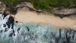 Dreamland beach bali drone aerial top view. beach with rocky cliff and white sand