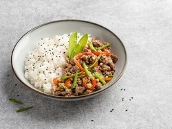 Rice with minced meat (duck), sweet red pepper, grean peas pods, black sesame and salted peanuts. Step by step cooking process. Tasty lunch or dinner. Traditional asian dish. Close up view, copy space