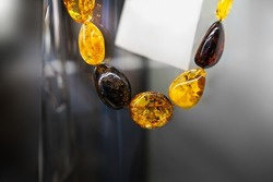 Amber beads on blurry gradient background. Close up.